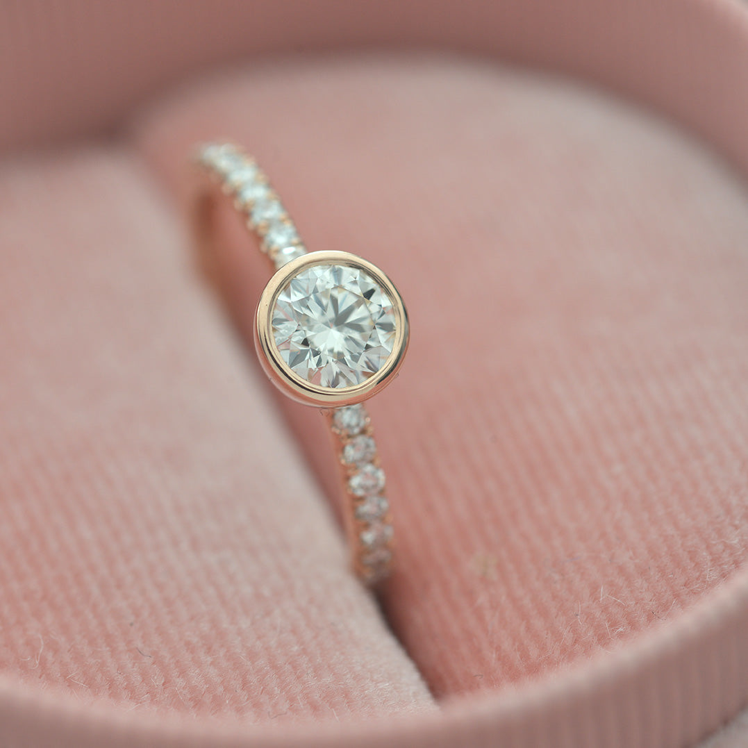 round bezel style engagement ring with pave in rose gold