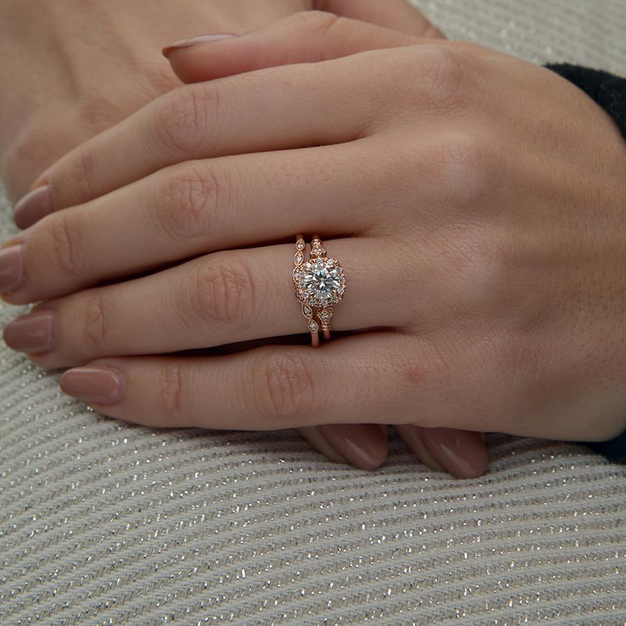 rose gold cushion halo engagement ring in a hand