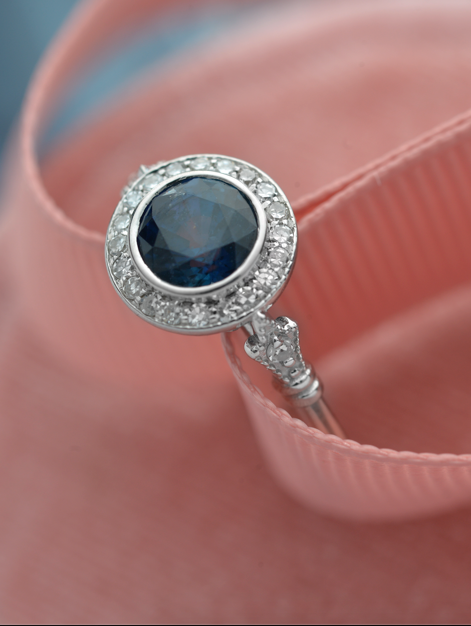 blue sapphire vintage engagement ring in white gold pink background