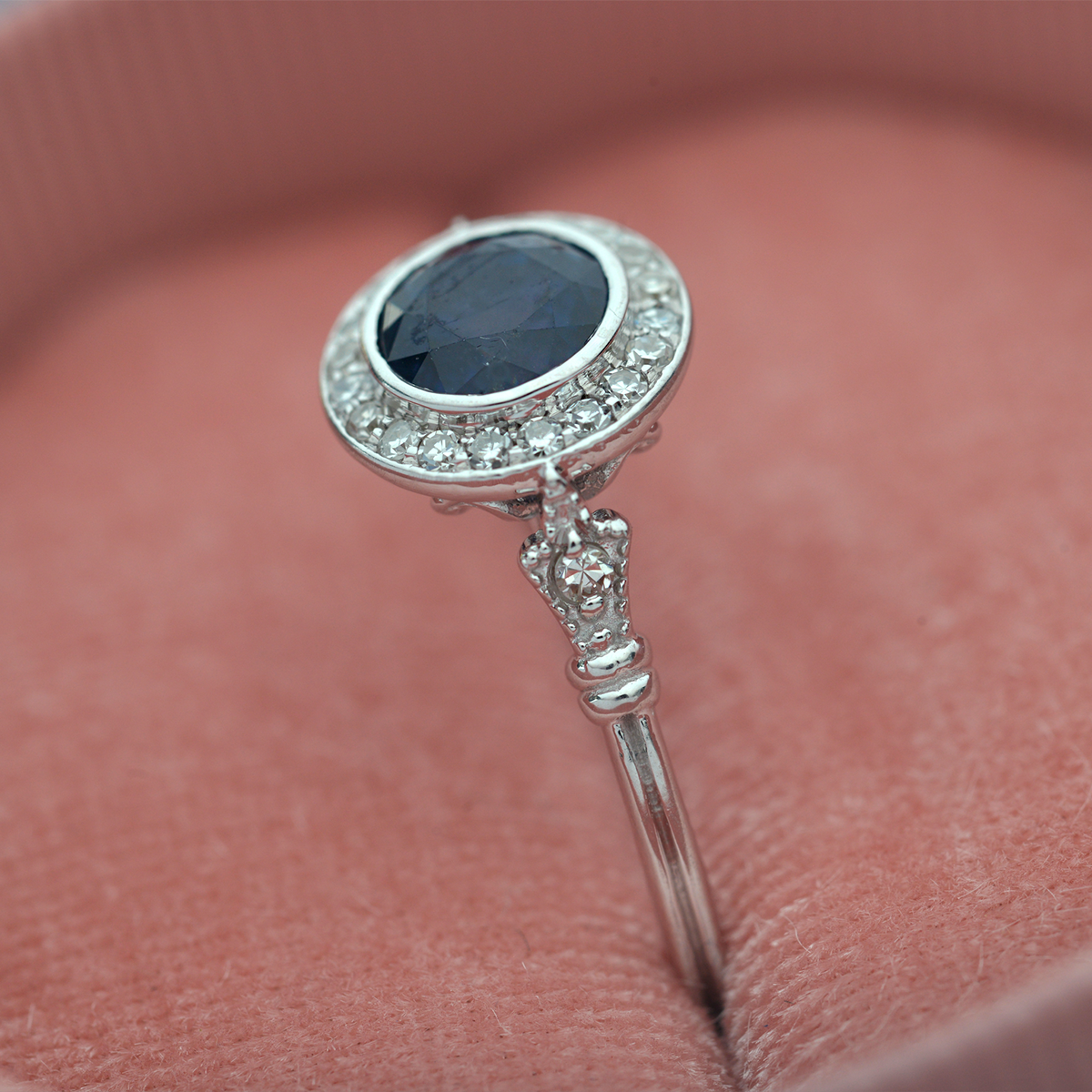 blue sapphire vintage engagement ring in white gold pink background