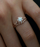 rose gold round halo flower engagement ring with band in a hand