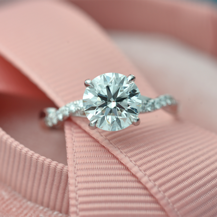 round solitaire engagement ring with twisted band with diamonds. 