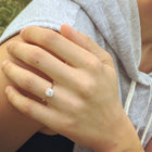 engagement ring with a cushion halo in a hand
