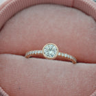 round bezel style engagement ring with pave in rose gold