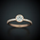 round bezel style engagement ring with pave in rose gold