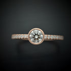 round bezel style engagement ring with pave in rose gold