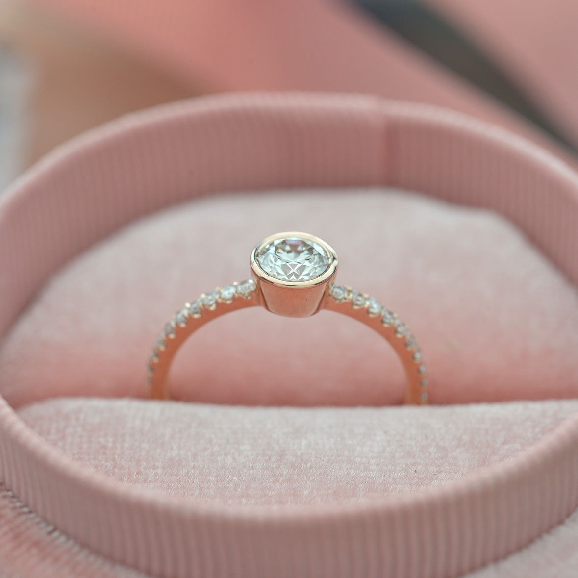 round bezel style engagement ring with pave in rose gold