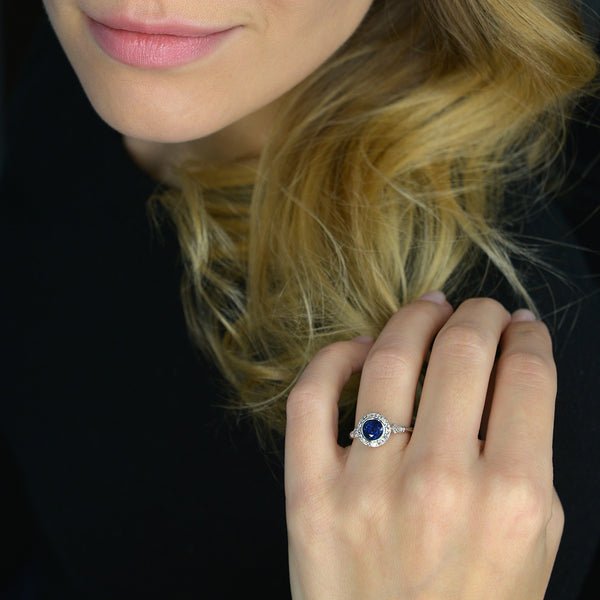 blue sapphire vintage engagement ring in white gold in a models hand