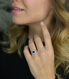 blue sapphire vintage engagement ring in a hand with model