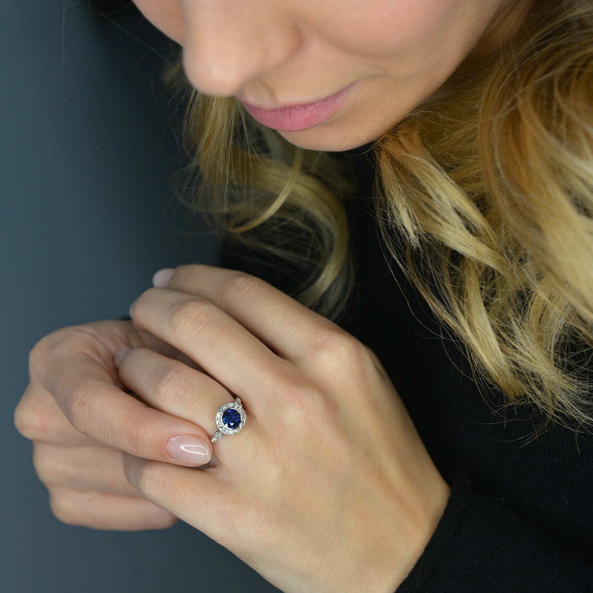 blue sapphire vintage engagement ring in white gold in a model's hand