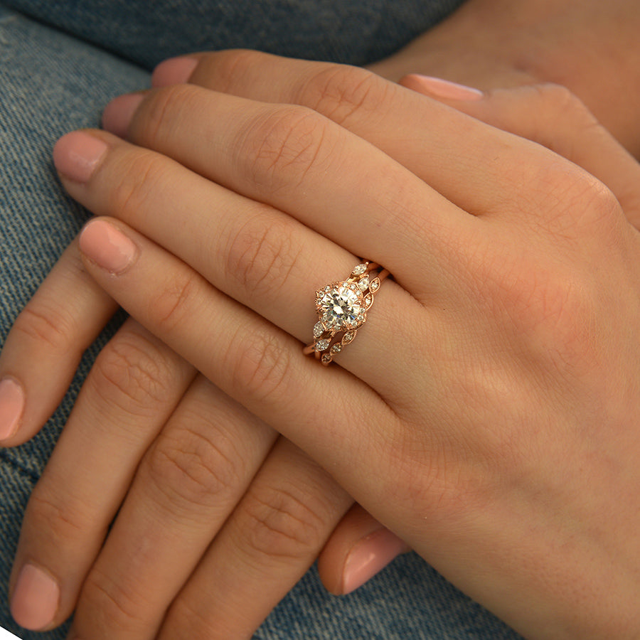 Rose gold engagement ring vintage inspired halo with a twist band  in a hand