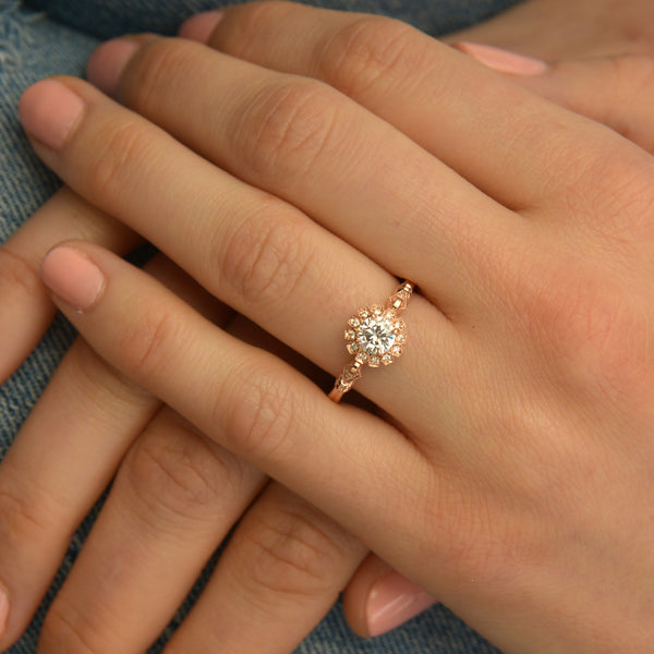 round halo vintage inspired engagement ring in rose gold  model's hand