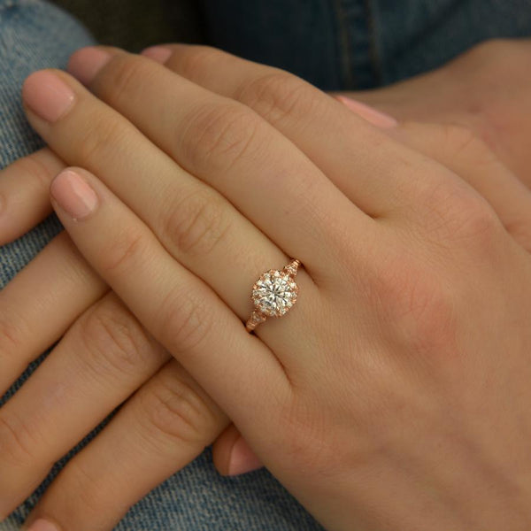 rose gold cushion halo engagement ring in a hand