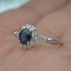 oval blue sapphire engagement ring in white gold vintage look in a hand