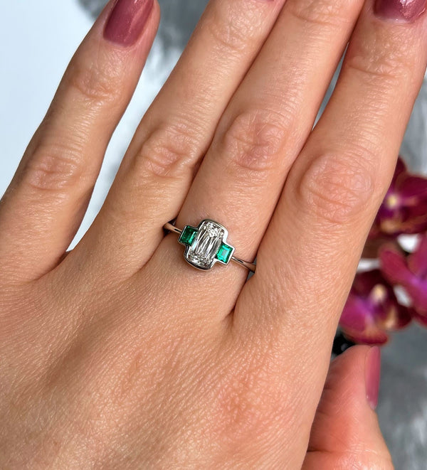 hand with bezel engagement ring with clolombian emeralds