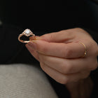 vintage cushion halo engagement ring in rose gold in models hand