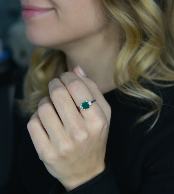 3 stone colombian emerald in white gold with traps on a model hand