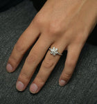 Diamond Flower Cluster Engagement ring in white gold in a hand