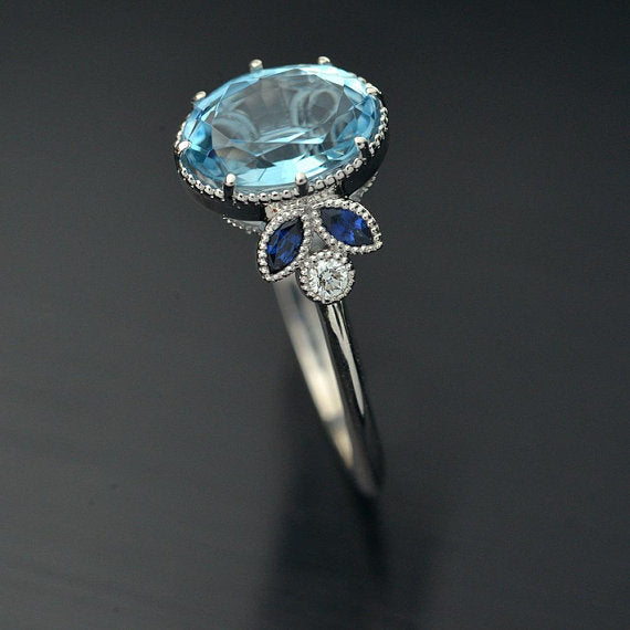 Oval blue aqua marine engagement ring with marquise sapphires side view