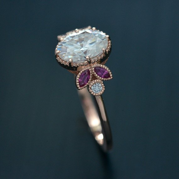 Oval engagement ring with marquise rubies in rose gold side view