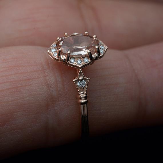 oval halo engagement ring vintage inspired with a morganite in rose gold in a finger